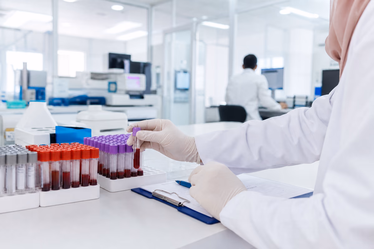 Laboratoire médical moderne à Alger avec tubes de prélèvement sanguin et dossier de dépistage sans texte lisible